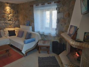 uma sala de estar com um sofá e uma lareira em Stymfalia stone house 