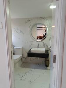 a white bathroom with a sink and a mirror at Two Seas Residence in Ooty