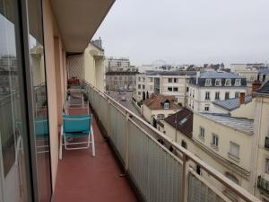 una silla en el balcón con vistas a la ciudad en La CAMPAGNE A LA VILLE en Dijon