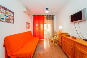 トレビエハにあるALEGRIA ID33のリビングルーム(オレンジ色のソファ、テレビ付)
