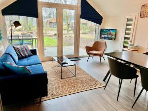 un soggiorno con divano blu e tavolo di Holiday Home Maridu Forest ad Arnhem