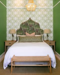 1 dormitorio con 1 cama con pared verde en The Belmont en Franschhoek