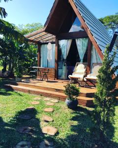 una cabina con 2 sillas y una mesa en una terraza en Chalé Envidraçado Recanto Verde dos Canyons, en Praia Grande