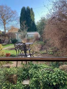 a bench sitting in a garden with a table at Little Reeds in Bovey Tracey
