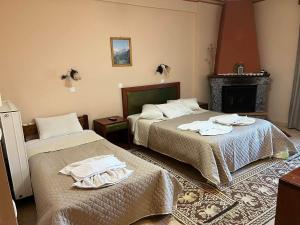 um quarto com 2 camas e uma lareira em To Spiti tis Irinis em Vytina