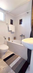 y baño con bañera, aseo y lavamanos. en Villa Βianca in Sithonia, en Gerakini