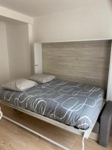マントンにあるAppartement Maroelviの木製のヘッドボードが付いたベッドのある寝室