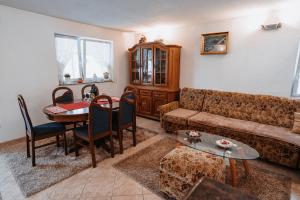 un soggiorno con un divano e un tavolo di CosyHouse-Kupres a Kupres