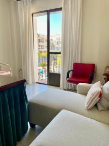 um quarto de hotel com uma cama e uma cadeira vermelha em Calle Valenzuela 9 La Rambla em La Rambla