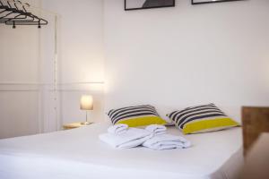 リスボンにあるOriginal Lisbon Guesthouseのベッドルーム1室(白いベッド1台、枕2つ、タオル付)