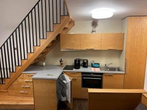 a kitchen with wooden cabinets and a staircase at Palava eu 8 in Pavlov
