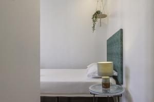 een slaapkamer met een bed met een kaars op een tafel bij The Color Hostel in Lissabon