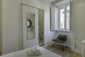 里斯本的住宿－The Color Hostel，白色卧室配有镜子和椅子