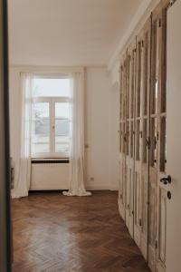 een lege kamer met een raam en een deur bij Bleyckhof in een uniek natuurgebied in Ranst