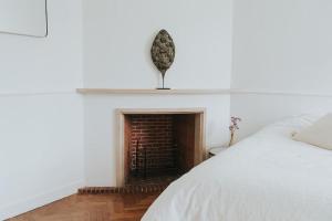 een slaapkamer met een bed en een stenen open haard bij Bleyckhof in een uniek natuurgebied in Ranst