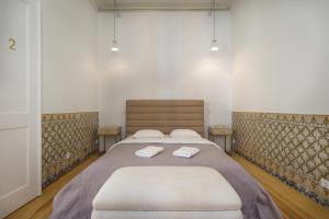 una camera da letto con un letto e due asciugamani di Santa Justa Prime Guesthouse a Lisbona
