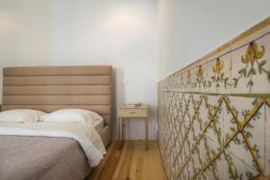 una camera con letto con testiera e tavolo di Santa Justa Prime Guesthouse a Lisbona