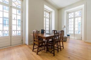 une salle à manger avec une table et des chaises en bois dans l'établissement Santa Justa Prime Guesthouse, à Lisbonne