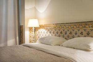 una camera con letto, 2 cuscini e una lampada di Santa Justa Prime Guesthouse a Lisbona