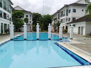 een groot blauw zwembad met witte zuilen en gebouwen bij Polo Park Apartment near mid valley southkey in Johor Bahru