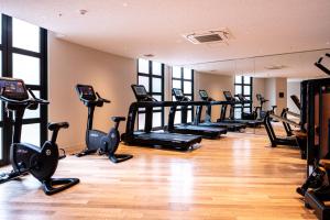 ein Fitnessstudio mit einer Reihe von Laufbändern und Crosstrainern in der Unterkunft THE BASICS FUKUOKA in Fukuoka