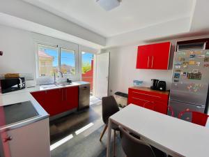 a kitchen with red cabinets and a table in it at Apartamento moderno con jardín cerca de la playa by Livingrincón in Rincón de la Victoria