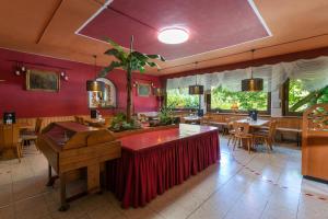 ein Restaurant mit roten Wänden, Holztischen und Stühlen in der Unterkunft Hotel Deis in Senheim