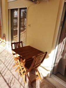 una mesa de madera y una silla en un porche en Serres Kavafi 7 city center , FREE PARKING , FREE NETFLIX en Serres