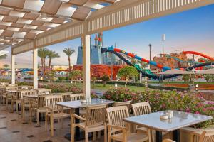 un patio con tavoli, sedie e montagne russe di Pickalbatros Aqua Blu Sharm El Sheikh a Sharm El Sheikh Altre 37 foto
