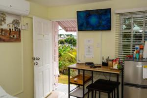 a kitchen with a table and a refrigerator and a window at Three Palm Villa in Montego Bay
