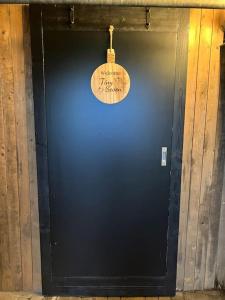 a black door with a clock on it at Tiny Seven in Otterlo