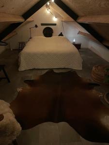 een slaapkamer met een wit bed op zolder bij Tiny Seven in Otterlo