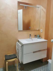 a bathroom with a sink and a mirror and a stool at Dunas Flat in Lavra