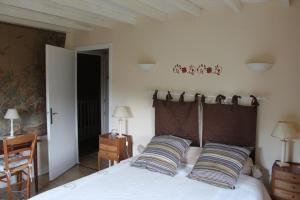 a bedroom with a large bed with two pillows at La Buissonnière in Saint-Vincent