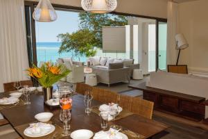 ein Esszimmer mit einem Tisch und Meerblick in der Unterkunft Esplanade by Horizon Holidays in Tamarin