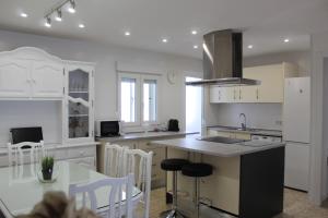 kuchnia z białymi szafkami i stołem z krzesłami w obiekcie Apartamento Calle Huelva by CasaTuristica w mieście Ronda