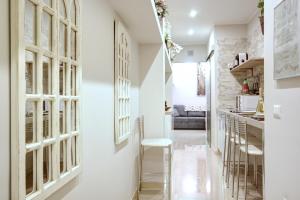 een hal met witte muren en een keuken met witte krukken bij MilanRentals - Charlie Apartment in Milaan