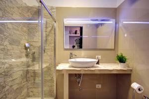 een badkamer met een wastafel en een glazen douche bij MilanRentals - Charlie Apartment in Milaan