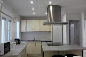 a kitchen with white cabinets and a stove top oven at Apartamento Calle Huelva by CasaTuristica in Ronda