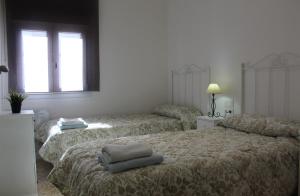 sypialnia z dwoma łóżkami i oknem w obiekcie Apartamento Calle Huelva by CasaTuristica w mieście Ronda