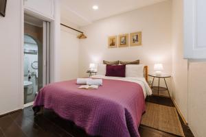 um quarto com uma cama grande e um cobertor roxo em Casa António Moreira em Óbidos