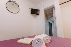 sypialnia z fioletowym łóżkiem i ręcznikami w obiekcie Casa António Moreira w mieście Óbidos