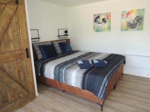 een slaapkamer met een groot bed met blauwe kussens bij Bed & Breakfast De Bodderie in Nieuwland