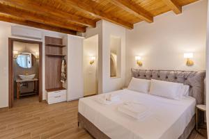 a bedroom with a large white bed with a mirror at Casa Del Balsamo in Rethymno Town