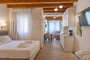 een slaapkamer met een bed en een keuken met een tafel bij Casa Del Balsamo in Rethimnon