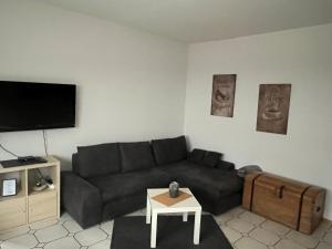 a living room with a couch and a tv at Ferienwohnung Staufenberg in Staufenberg