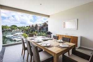 een eetkamer met een tafel en stoelen en een groot raam bij West Coast Marina in Rivière Noire