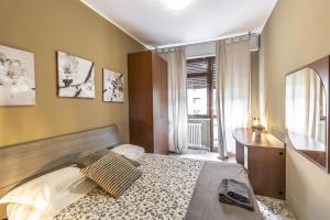 um quarto com uma cama, uma secretária e uma janela em MilanRentals - Vigliani Apartments em Milão