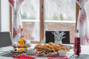 un tavolo con un piatto di dolci e pane sopra di Pensiunea Cascada a Nemesi