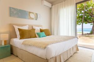 a bedroom with a bed with a view of the ocean at Manta Cove by Horizon Holidays in Tamarin